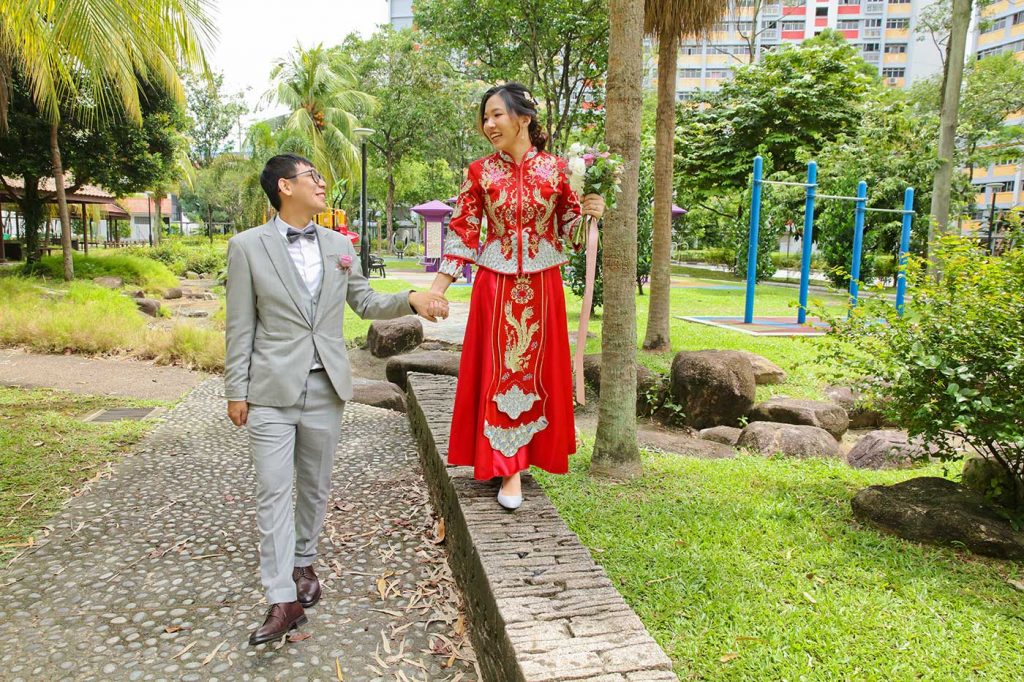 Bride in Chinese red kua and groom at HDB estate playground Singapore actual day photo