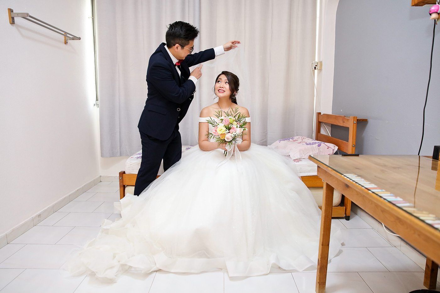 Groom presenting bouquet to bride at door during wedding morning gate crash Singapore