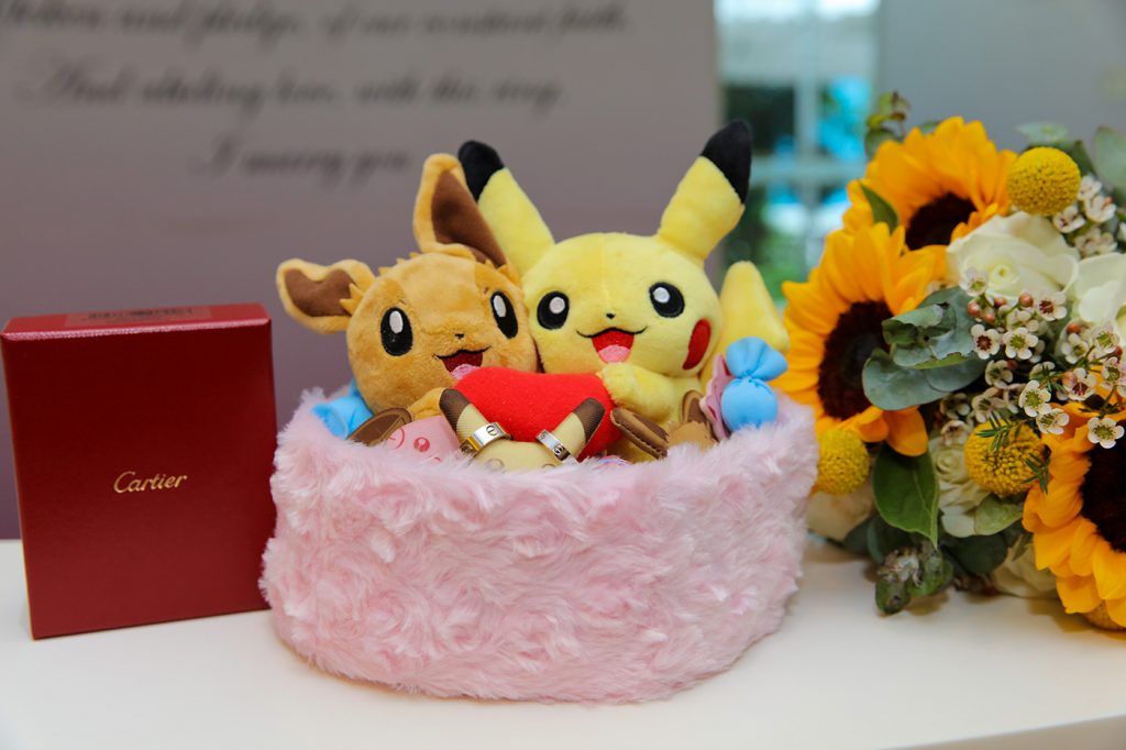 Wedding gift table with Pikachu plush Cartier box and sunflowers reception decor