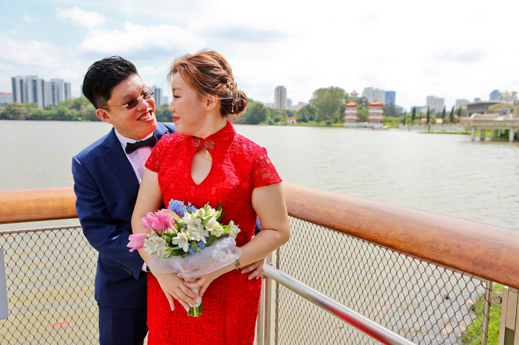 Couple in traditional Chinese red kua wedding attire by Singapore waterfront