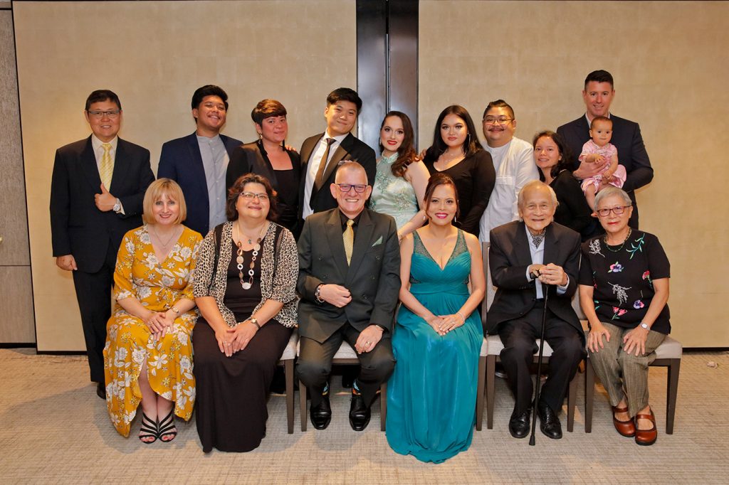Wedding family group portrait with bridal party on hotel bed Singapore