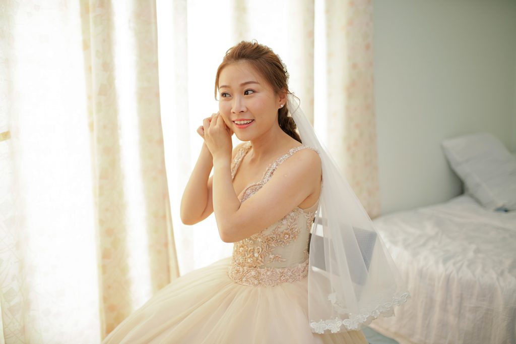 Bride getting ready portrait with earrings during bridal preparation in hotel room