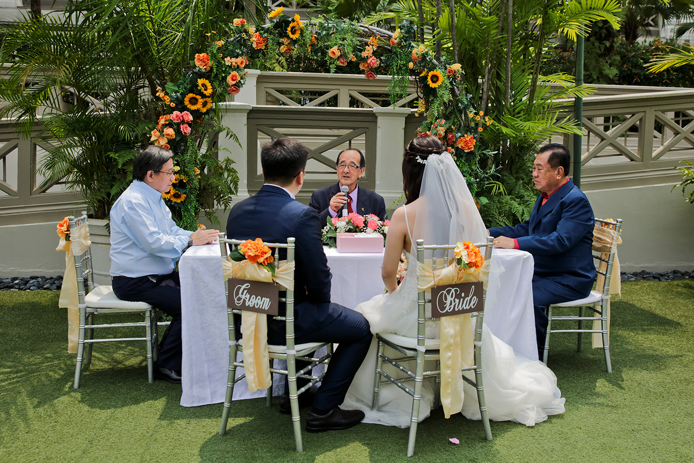 Outdoor garden ROM solemnization ceremony setup with groom and bride chair signs