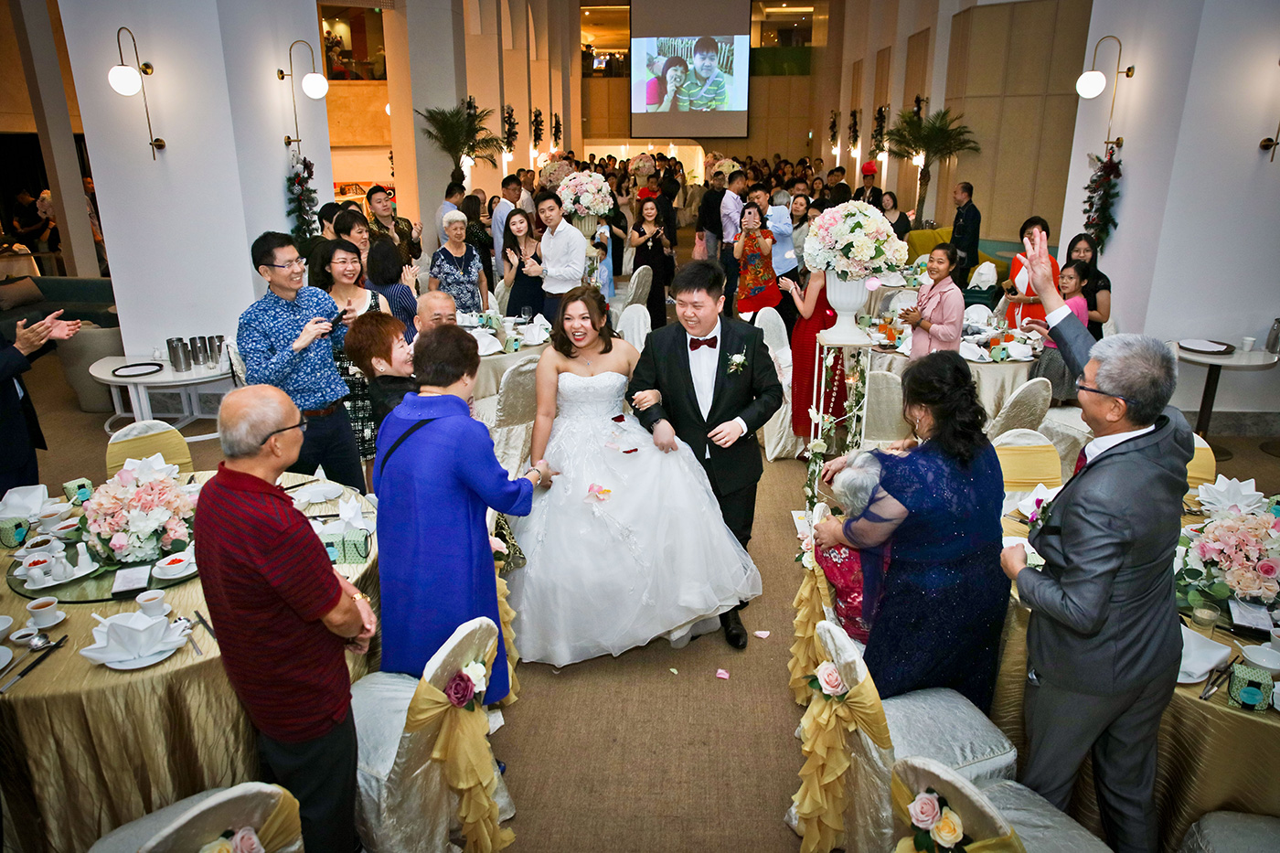 Bride and groom at wedding solemnization ceremony with white floral arch in Singapore