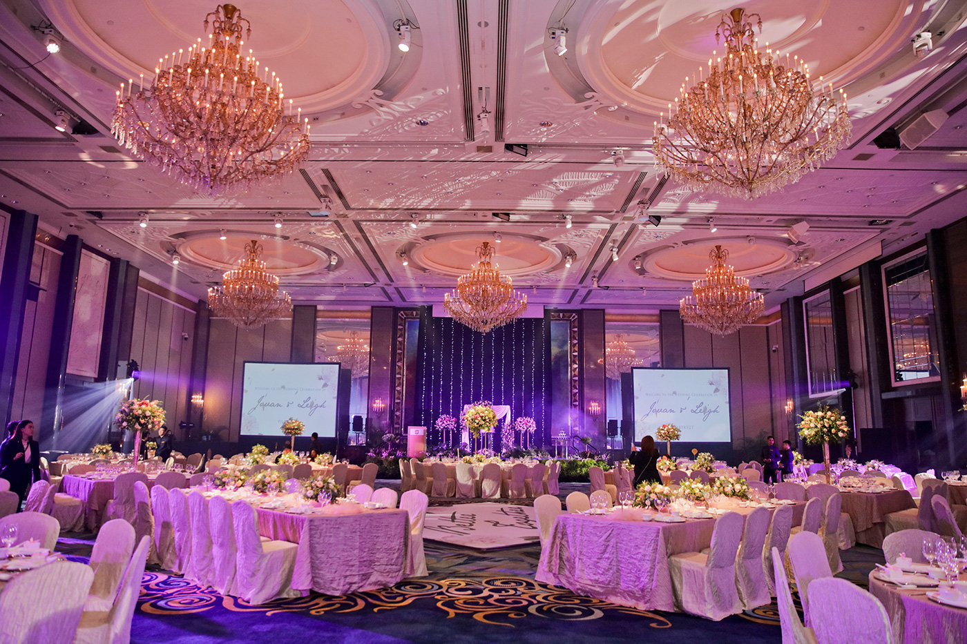 Purple-lit wedding banquet ballroom setup with chandeliers at Singapore hotel