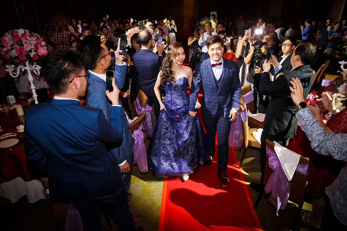 Wedding banquet march-in with guests cheering at Singapore hotel ballroom reception