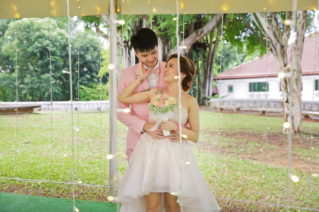 Bride and groom under fairy lights at outdoor garden pavilion Singapore wedding
