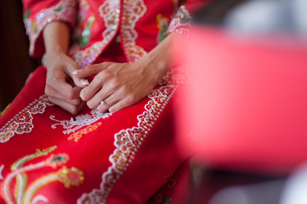 Bride hands with henna mehndi art and wedding rings on red fabric Indian wedding Singapore