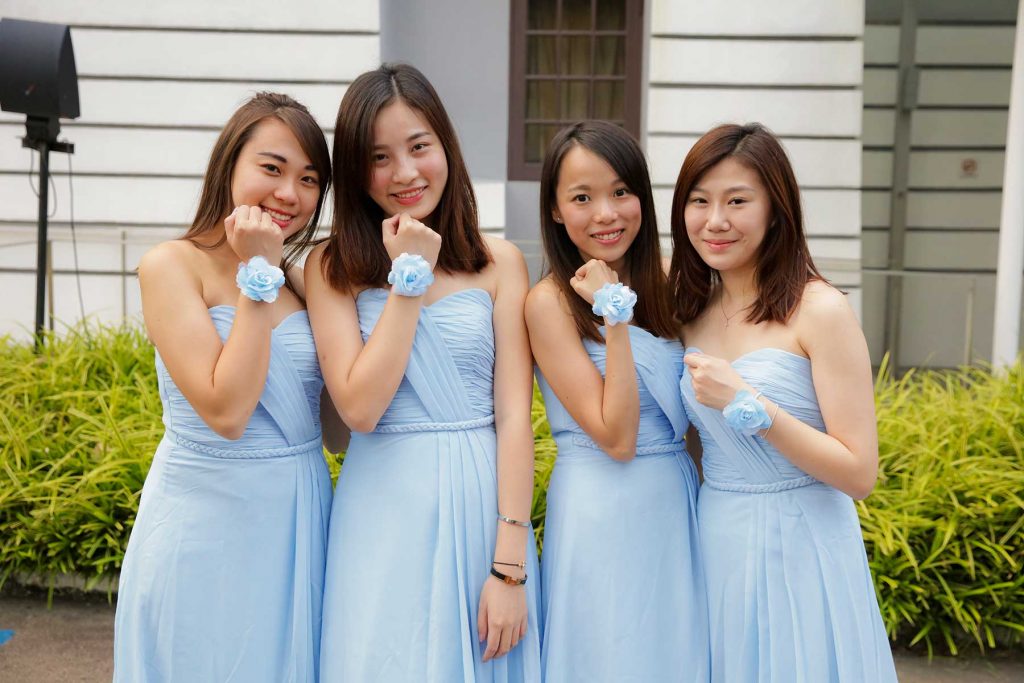 Three bridesmaids in matching light blue dresses holding bouquets Singapore wedding