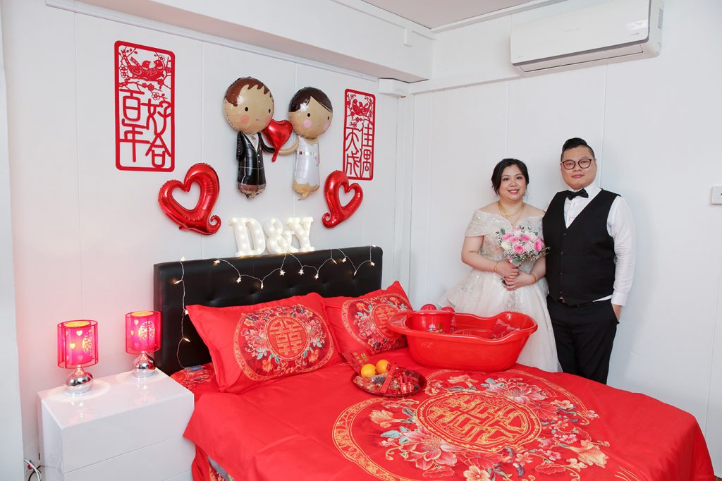 Chinese wedding An Chuang bed setting with red sheets double happiness symbol and champagne