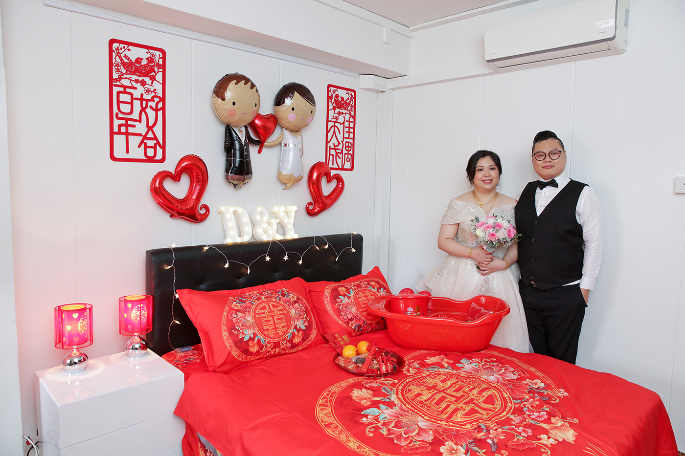 Chinese wedding An Chuang bed setting with red sheets double happiness symbol and champagne