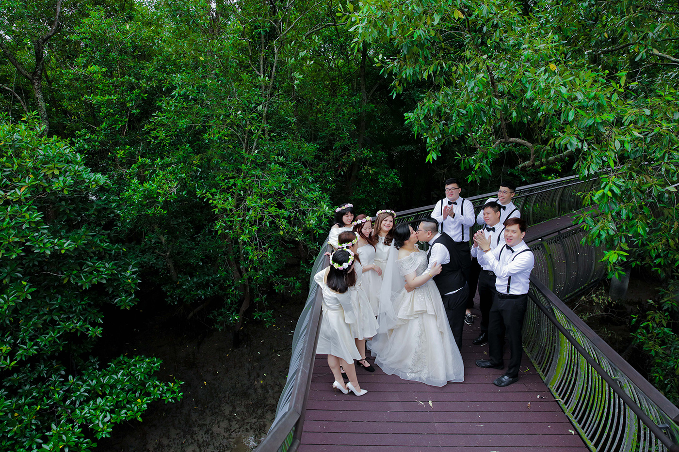 Bridal party group photo on outdoor staircase surrounded by tropical greenery Singapore