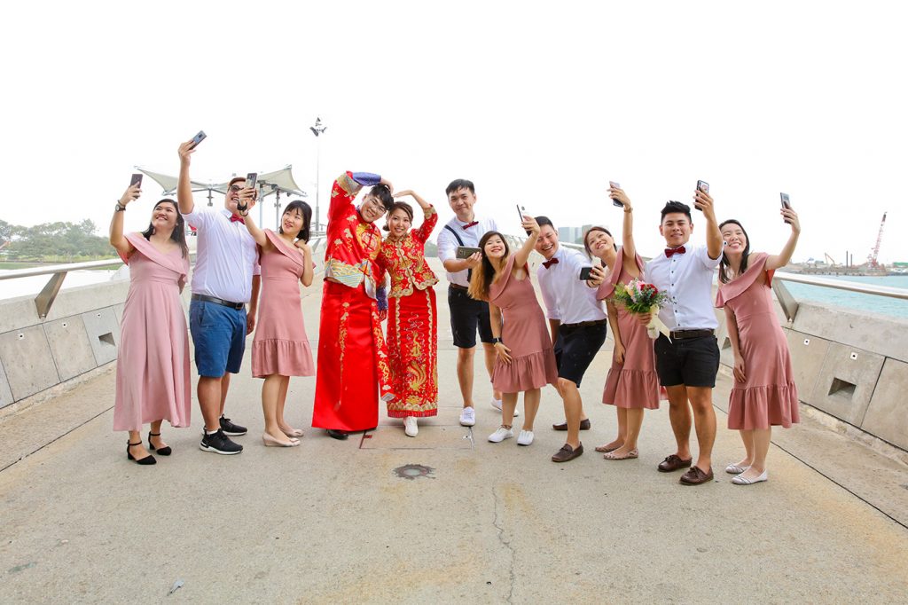 Full bridal party poolside group photo with bride in Chinese red kua Singapore