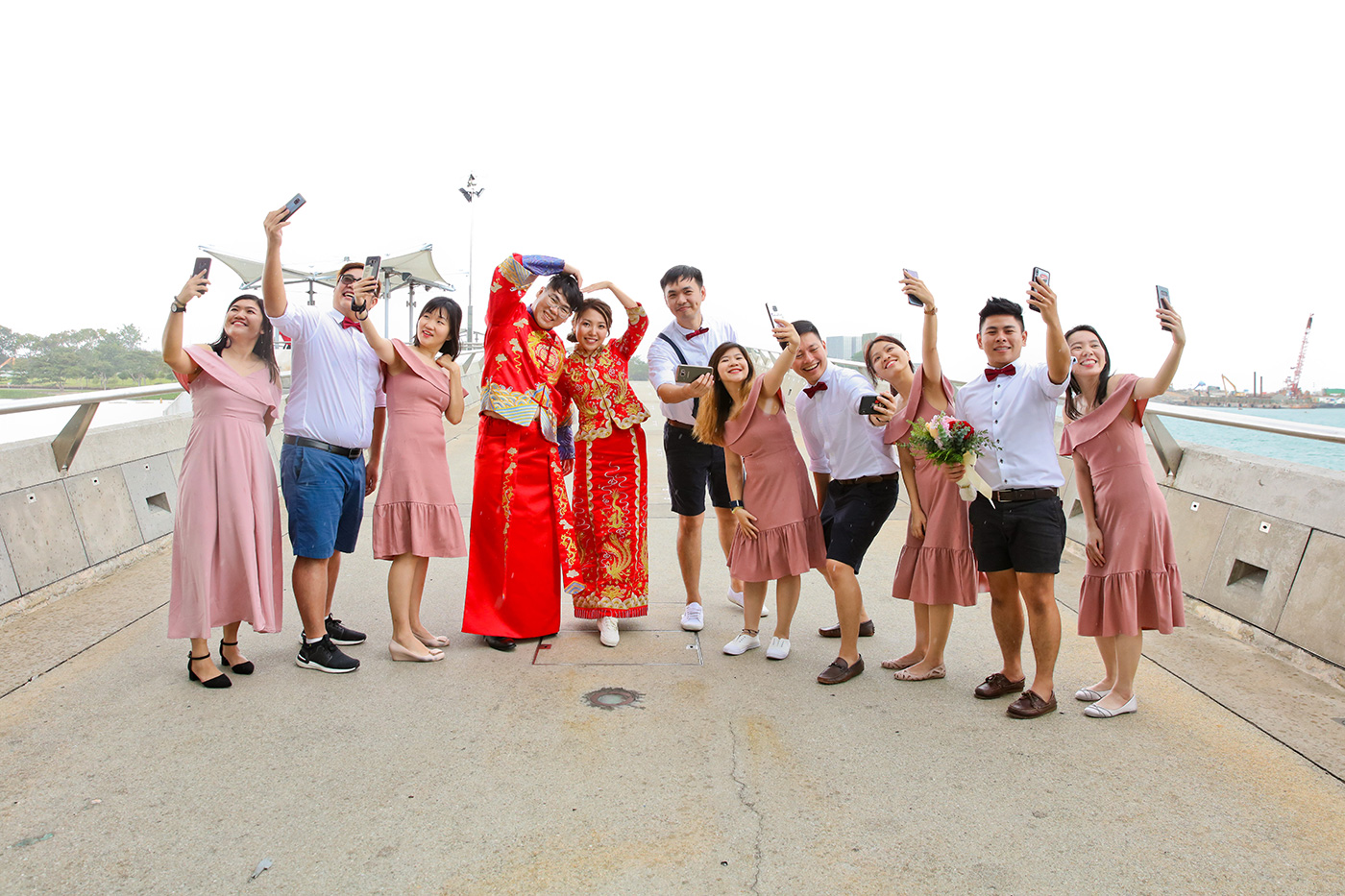 Full bridal party poolside group photo with bride in Chinese red kua Singapore