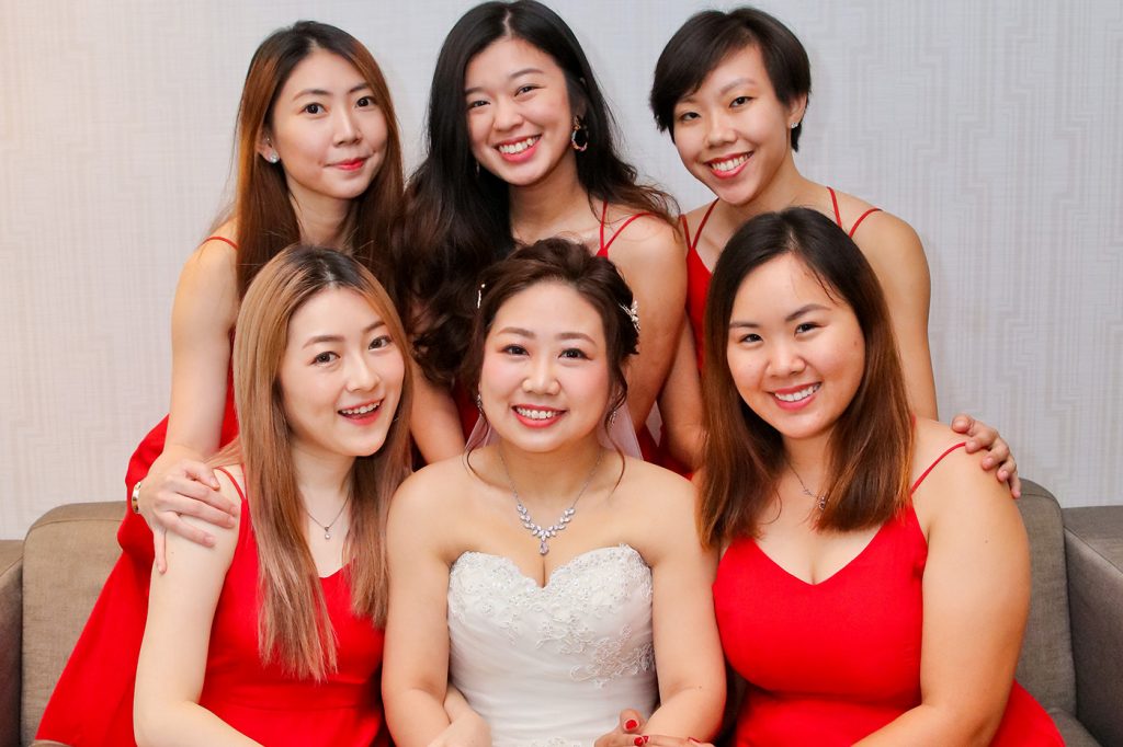 Bridesmaids group portrait in matching coral dresses with bride Singapore wedding